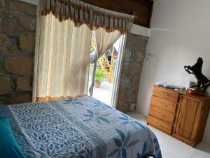 um quarto com uma cama, uma janela e uma cómoda em Hostal El Cascol em Puerto López