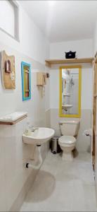 a white bathroom with a toilet and a sink at Alojamiento Rural Jardín Consentido in Jardin