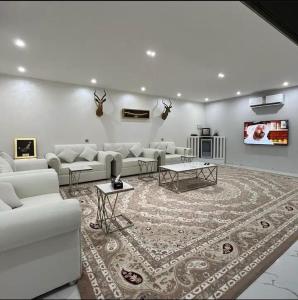 a living room with white couches and a rug at Elva farm in Sinādil