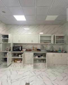 a kitchen with white cabinets and a tile floor at Elva farm in Sinādil