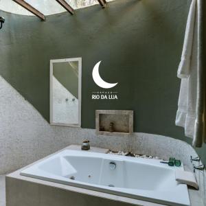 a bath tub in a bathroom with a sign on the wall at Casa de Madeira - Sao Jorge GO in Sao Jorge +75 photos
