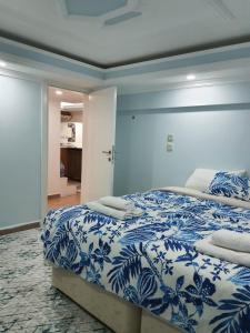 een slaapkamer met een bed met een blauw en wit dekbed bij VillaSun Kleopatra in Alanya