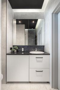 a white bathroom with a sink and a mirror at Cozy Modern Corner by ECRU WWA59 in Warsaw
