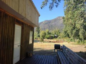 een bankje op een veranda van een huis bij Cabañas Precordillera Radal 7 tazas in El Torreón