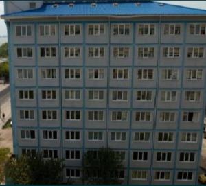 a tall gray building with a blue roof at Marina Portului Studio in Galaţi