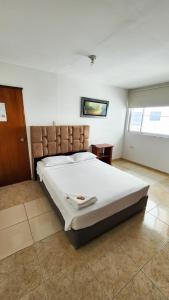 a bedroom with a large white bed in a room at Hotel Sierra Nevada B&B SAS in Valledupar