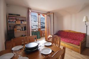 une salle à manger avec une table et une chambre avec un lit dans l'établissement Appart - Chalet du Hameau des Aiguilles, à Albiez-Montrond