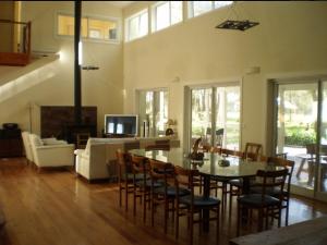 comedor y sala de estar con mesa y sillas en La casa de 10GO en Cariló