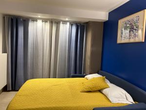a bedroom with a bed with a yellow blanket at Appartement Cambita in Montévrain