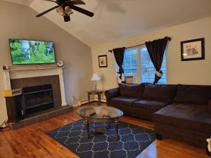 ein Wohnzimmer mit einem Sofa und einem Kamin in der Unterkunft Cozy Home away from Home in Westbrookville