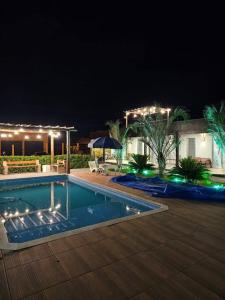 a swimming pool in a yard at night at Rancho condomínio Terras d barra 