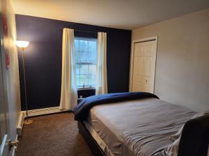 Schlafzimmer mit einem Bett und einem Fenster in der Unterkunft Cozy Home away from Home in Westbrookville