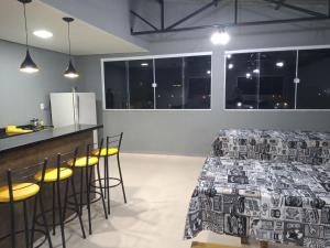 TRIPLEX COM SALÃO DE FESTAS À 1.3 KM DA PRAIA في بيساراس: غرفة مع سرير وبار مع الكراسي +15 صورة