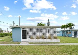 a blue and white house with a yard at Midtown Cottage - In the heart of Cocoa Beach in Cocoa Beach