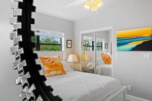 可可比奇的住宿－Midtown Cottage - In the heart of Cocoa Beach，卧室配有一张床,墙上挂有绘画作品