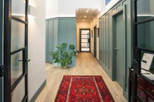 a hallway with a red rug on the floor and a door with a plant at New build eco house in walled garden, Rostrevor in Rostrevor