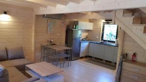 een keuken en een woonkamer in een blokhut bij Domek na Barcowej in Ostrowo