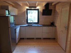 een kleine keuken met een wastafel en een raam bij Domek na Barcowej in Ostrowo