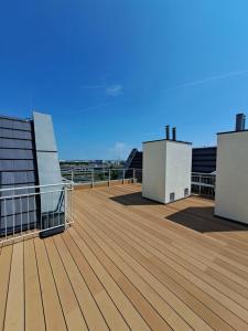 einen Balkon in einem Gebäude mit einer Holzterrasse in der Unterkunft Apartament Kryształowy in Stettin