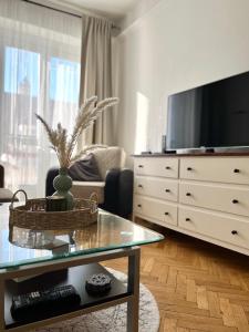 sala de estar con TV y mesa de cristal en Audrey Hepburn Apartment old town Air Conditioned, en Bratislava