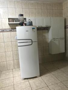 a small white refrigerator in a kitchen with at Michele in São Pedro da Aldeia +1 photo