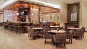 um restaurante com mesas e cadeiras e um bar em Hyatt Place San Juan em San Juan