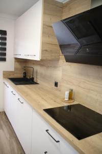 a kitchen with white cabinets and a black counter top at El Rincón de Eli in Rincón de la Victoria