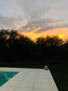 un tramonto su una piscina con una bicicletta sull'erba di Casa amplia con pileta a Villa Parque Síquiman