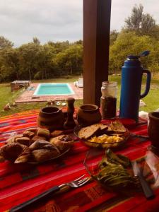 einen Tisch mit einem Teller Essen darüber in der Unterkunft Casa amplia con pileta in Villa Parque Siquiman