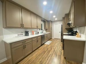 a large kitchen with wooden floors and cabinets in a room at NEW! Luxury Home in Central McAllen in McAllen