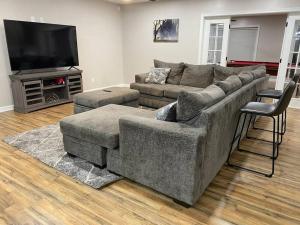 a living room with a couch and a flat screen tv at NEW! Luxury Home in Central McAllen in McAllen