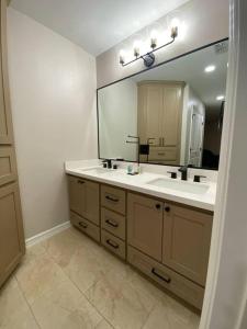 a bathroom with a sink and a large mirror at NEW! Luxury Home in Central McAllen in McAllen