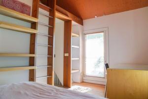 1 dormitorio con estanterías y 1 cama con ventana en Comfortabele woning aan het water, hottub & kachel, en Zuidlaren
