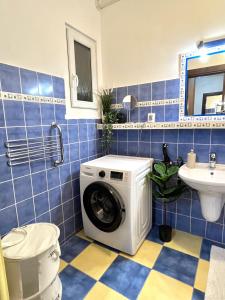 a blue tiled bathroom with a washing machine at Audrey Hepburn Apartment old town Air Conditioned in Bratislava