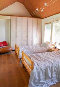 1 dormitorio con 2 camas y ventana en Comfortabele woning aan het water, hottub & kachel, en Zuidlaren