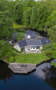 una vista aérea de una casa en una isla en el agua en Comfortabele woning aan het water, hottub & kachel, en Zuidlaren