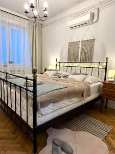 a bedroom with a black bed and a chandelier at Audrey Hepburn Apartment old town Air Conditioned in Bratislava