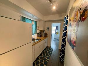 a kitchen with a refrigerator and a sink at Nobleton Hotel in Fort Lauderdale