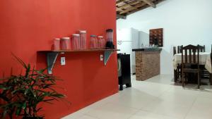 Una cocina con una pared roja y un refrigerador rojo. en Casa em Pradim de açúcar, en Prado