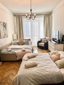1 dormitorio con 2 camas y lámpara de araña en Audrey Hepburn Apartment old town Air Conditioned, en Bratislava