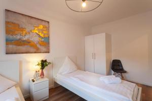 ein Schlafzimmer mit einem weißen Bett und einem Stuhl in der Unterkunft City Apart Hannover in Hannover