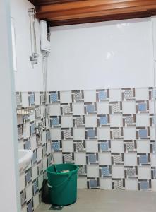 uma casa de banho com um balde verde ao lado de um lavatório em JB Home sweet home Perfect for Family & Friends em Babag