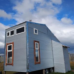 a tiny house is parked on the grass at Tyni house in Puerto Natales