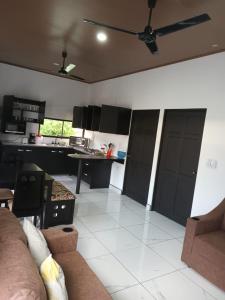 een woonkamer met een bank en een keuken bij Apartamento Rodriguez in Quepos