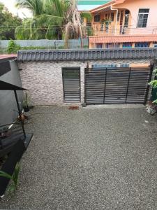 a house with a garage with a gate and a building at Apartamento Rodriguez in Quepos