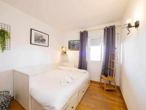 een slaapkamer met een wit bed en handdoeken bij Ático con vistas al mar piscina y parking in Málaga
