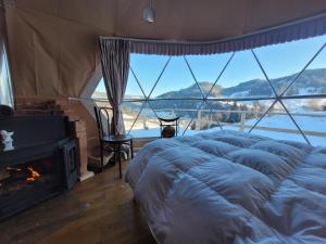 a bed in a tent with a fireplace in a room at Cucu Zen Dome Cabana Cazare Bucovina 