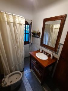 ein Badezimmer mit Waschbecken, Spiegel und Toilette in der Unterkunft Casa en Sierras de Córdoba, Villa la Bolsa. in La Bolsa