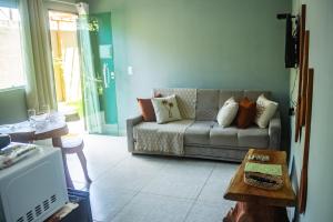 a living room with a couch and a table at Portuá Chalés in São Miguel dos Milagres