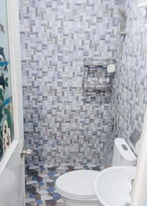 a bathroom with a toilet and a tiled wall at JB Home sweet home Perfect for Family & Friends in Babag